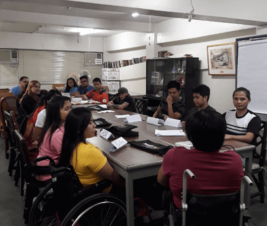Persons with Disability and their colleagues seated around a table for a meeting